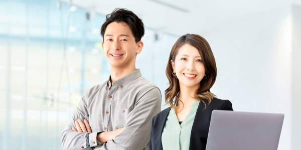 スマホを持ち微笑む人物の画像